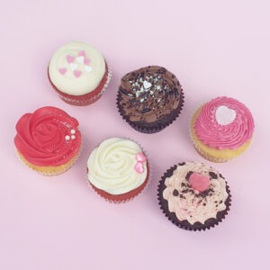 Valentine's Day themed cupcakes. Assortment of designs with pink, red and white frosting and various heart decorations